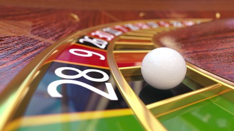 Closeup view at casino roulette table with rotating wooden roulette wheel with gaming ball in the win black slot. Gambling games in night casino club and playing with fortune. Win jackpot or broke.