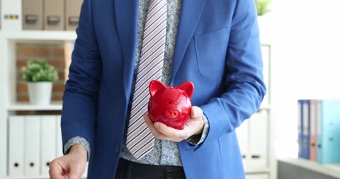 Businessman tosses coin into piggy bank 4k movie