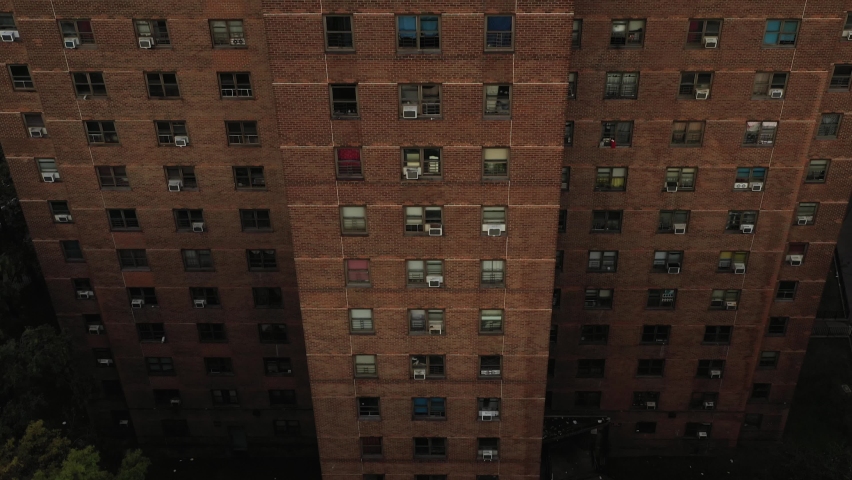 dramatic aerial tilt up along vertical axis of housing project building in East Harlem New York City in the early morning revealing the skyline Royalty-Free Stock Footage #1081103351