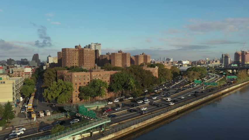 aerial shot follows cars uptown on the Harlem River Drive in New York City, schoolbuses in interest Royalty-Free Stock Footage #1081103645