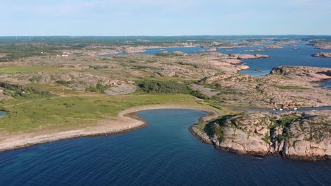 Natural bay and islands on the swedish west coast. Granite rock coastline an open ocean. Distant lighthouse in windy blue water High angle aerial drone shot Bohuslän Tjurpanna national park preserve