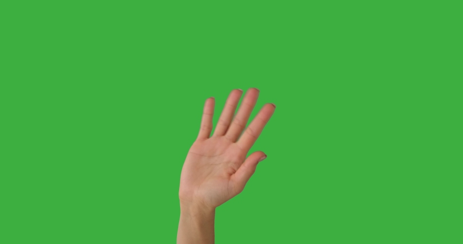 Woman waving her hand over green screen