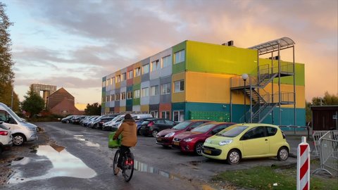 GRONINGEN, NETHERLANDS - 22. OCTOBER 2021: Bicycle food delivery to Colorful Shipping Container Student homes. Temporary accomodation in the Housing Shortage
