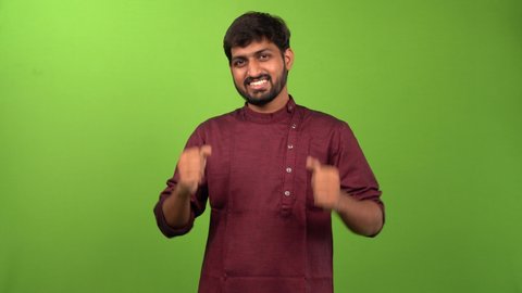 Indian handsome man giving thumbs up in a green screen portrait shoot.