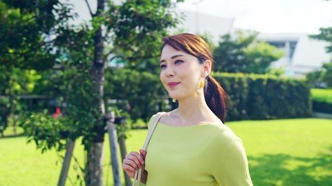 Young asian woman walking in the park.