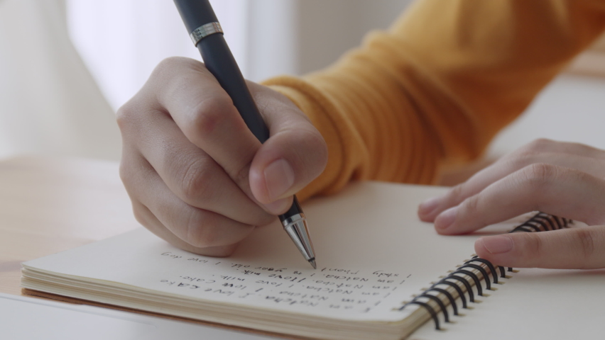 Hand of young women writing a notebook, doing homework, Concept of lifestyle and work at home. Close-up of  woman hand | Shutterstock HD Video #1081132310