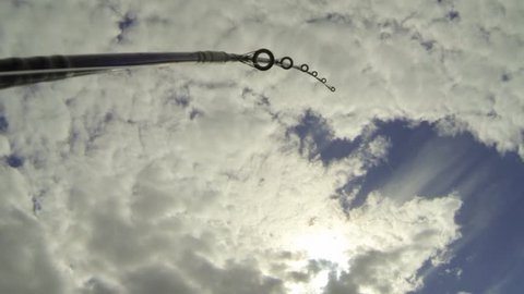 Wide angle shot of a troll fishing rod bending strongly and pointing towads the sky while trolling.