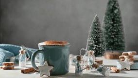 Christmas drink. Sprinkle marshmallows into hot chocolate in blue mug and gingerbread stars cookies with white glaze and decoration. 4K 50 fps video footage