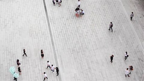 Group of people walking on plaza in pedestrian zone - aerial top view