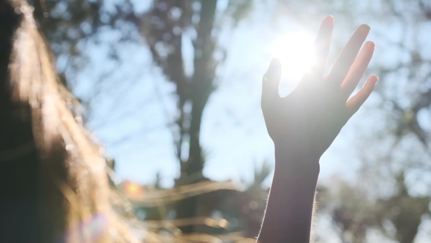 Hand of happy girl at sunset. Sunset between the hands of girl. Happy girl with long hair dreamily stretches out her hand to the sun. Child's dream hand to the sun. happy family concept Royalty-Free Stock Footage #1081145096