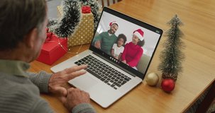 Happy caucasian senior man on video call with family at christmas time. christmas, festivity and communication technology.