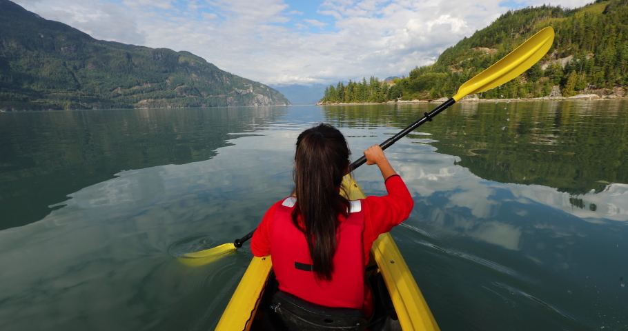 Woman kayaking in Squamish paddling in kayak in Howe Sound a fjord surrounded by mountains. People living healthy active outdoor lifestyle in British Columbia, Canada Royalty-Free Stock Footage #1081155326