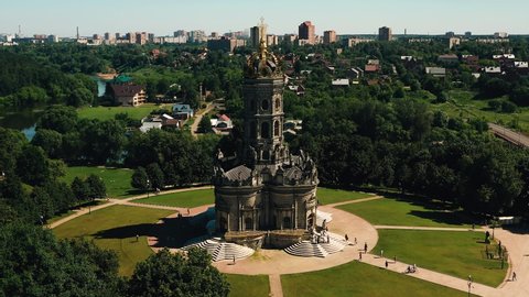A very beautiful christian church in the form of a tower stands on the site surrounded by a park area shooting from the air