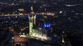 Establishing Aerial View Shot of Marseille Fr, Bouches-du-Rhone, Provence-Alpes-Cote d'Azur, France, at night evening, stunning Basilique Notre-Dame de la Garde