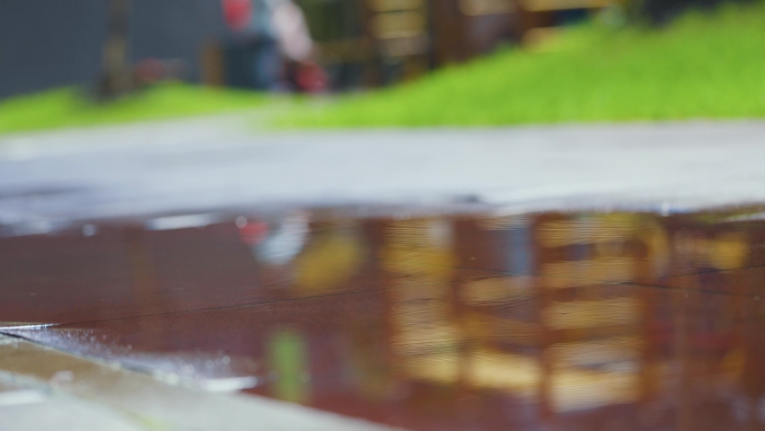 Female sports woman jogging outdoors, stepping into puddle. Single runner running in rain, making splash. Slow motion