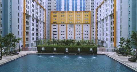 Serpong, Indonesia - March 17, 2021: Established Shot of Swimming Pool Surrounded by Apartment Buildings