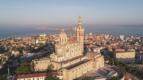 Establishing Aerial View Shot of Marseille Fr, Bouches-du-Rhone, Provence-Alpes-Cote d'Azur, France, Basilique Notre-Dame de la Garde, early morning, circling to the right