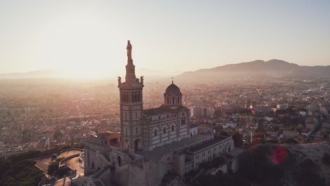Establishing Aerial View Shot of Marseille Fr, Bouches-du-Rhone, Provence-Alpes-Cote d'Azur, France, 
Basilique Notre-Dame de la Garde, push in and passing extermly close tower in the blissful blast