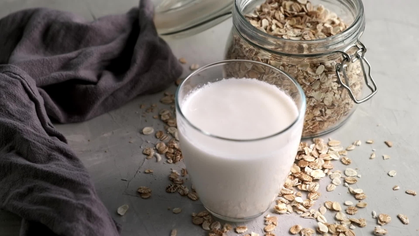 Oat Milk in the glass. Circular motion oat milk and bottle. Vegan concept. Royalty-Free Stock Footage #1081171163