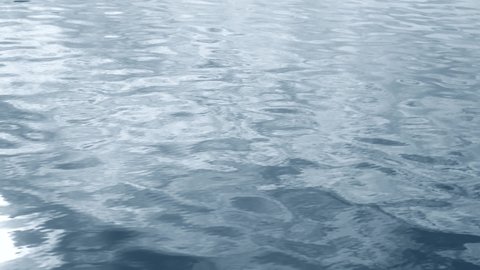 Close-up view 4k stock video footage of beautiful clear and clean blue smooth surface of peaceful rippling waves of sea water. Abstract liquid organic background