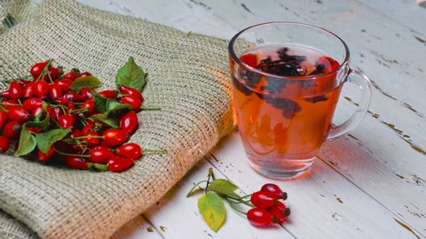 Natural tea from wild rose berries on vintage wooden boards. The red berry is used in homeopathy.
