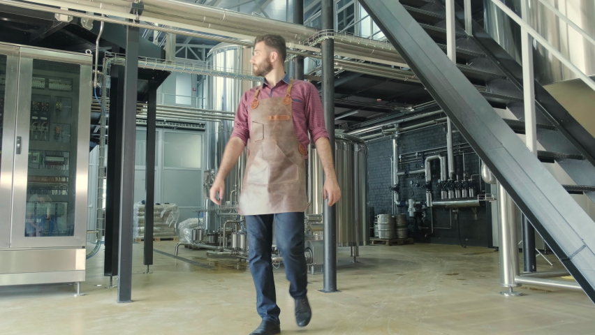 Young male brewer works at a modern brewery