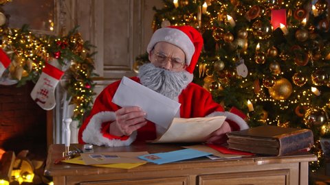 Santa Claus (Father Christmas, Kriss Kringle) writes answers to children's letters. The wizard carefully reads the wishes of the guys. Waiting for a miracle and magic. Christmas and New Year holiday