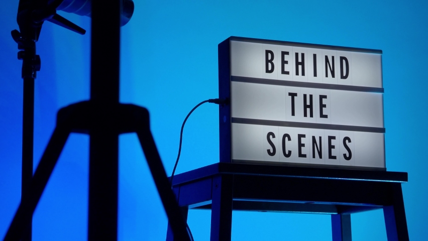 Behind the scene light box. Black text on white lightbox of word Behind the scenes. prop include megaphone movie clapperboard and director chair in studio. footage for video production making of. | Shutterstock HD Video #1081190984