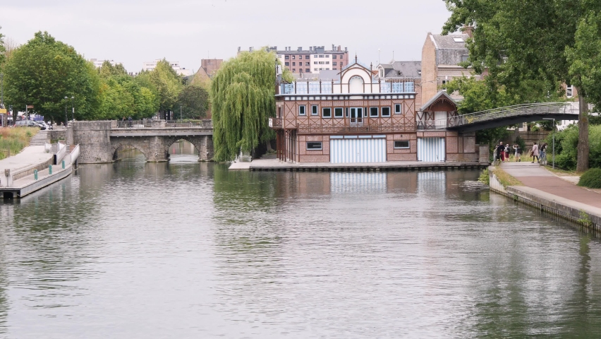 View of a canal in Amiens in the Picardy region of France with bridges and small boats in the distance
