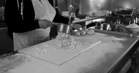 Woman using potato press for fresh made gnocchi inside pasta factory