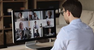 Virtual briefing. Over shoulder view male worker meet with leader colleagues by pc screen discuss sales at video conference mode. Young man remote employee work online communicate with business team