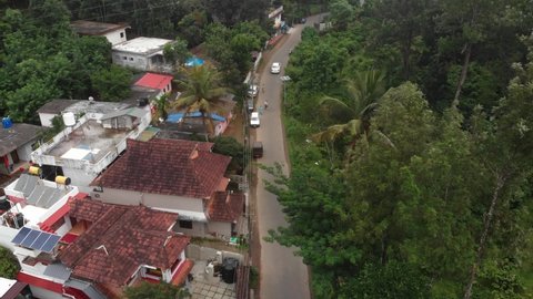 Aerial of Typical Indian Street in Rural Town of Thekkady with Cars, Scooters and Palms in State of Kerala, India near Periyar National Park