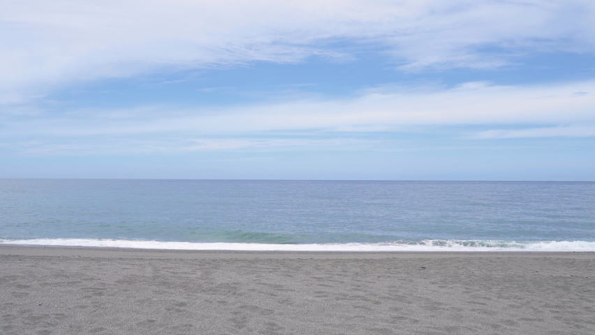 beautiful tropical sand beach with ocean waves and white cloud in blue sky at background. summer vacation concept.