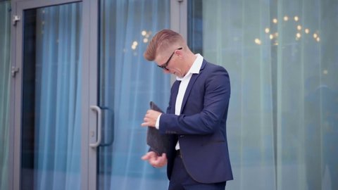 Businessman Standing outdoors with folder in hand near Office Building Entrance Handsome Caucasian Male Business Person Portrait 