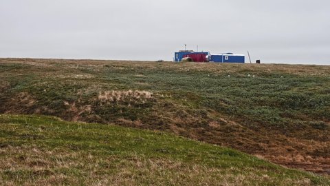 Place of living of expedition group. Land of Yamal Peninsula covered with grass and sand.