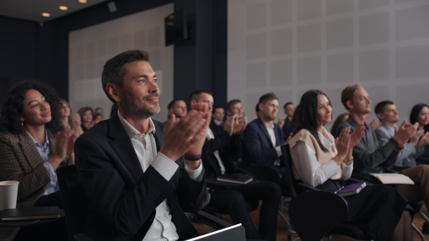 Group of people applauds to speech at business conference. Stage talk at summit meet in crowded modern hall. Caucasian executive man training at economy forum. Applause of male person in suit indoors Royalty-Free Stock Footage #1081228202