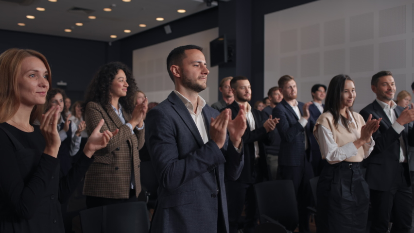Group of people applauds to speech at business conference. Stage talk at summit meet in crowded modern hall. Caucasian man training at economy forum. Applause of corporate male person in suit indoors | Shutterstock HD Video #1081228217