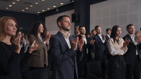 Group of people applauds to speech at business conference. Stage talk at summit meet in crowded modern hall. Caucasian man training at economy forum. Applause of corporate male person in suit indoors - Powered by Shutterstock - Get 15% off with code: PIKWIZARD15