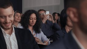 Group of people listens speech at business conference. Stage talk at summit meeting in crowded modern hall. Mixed race woman training at economy forum. Business work of sitting female person indoors - Powered by Shutterstock - Get 15% off with code: PIKWIZARD15