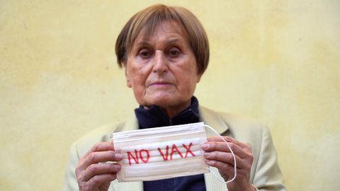 Europe, Italy ,  Lady 70 years old  with mask with write no vax   against Covid-19 Coronavirus outbreak - anti vaccine
