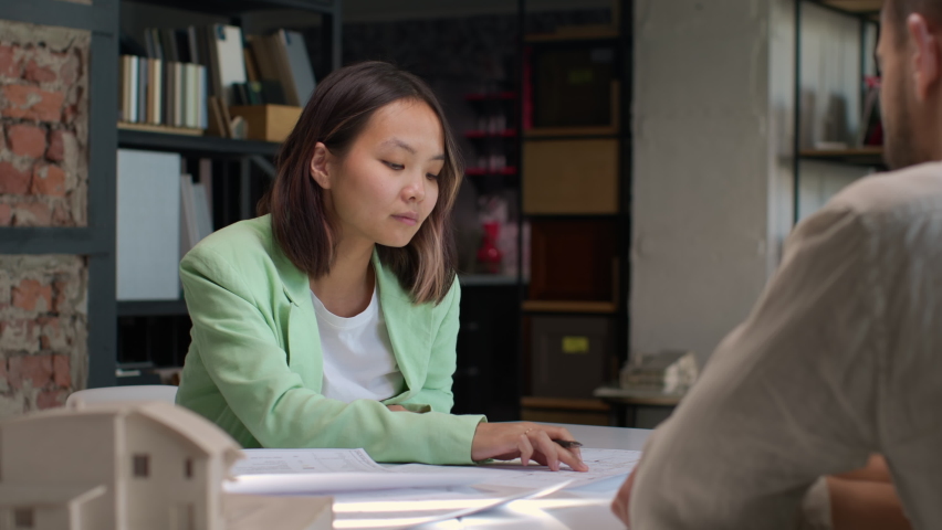 Home buyer at modern office table signs contract on buys real estate. Asian customer makes deal and purchases residential house. Signature on official document for selling realtor. Client paper work | Shutterstock HD Video #1081232495