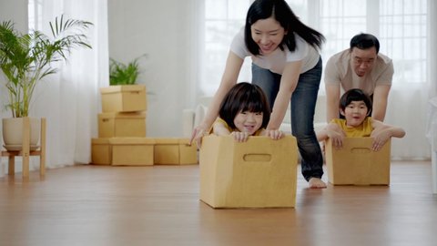 asian family playing with a box. Together having fun inside the house
