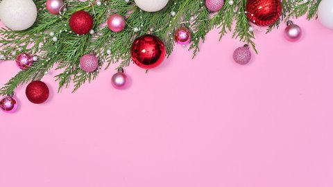 6k Red pink and white Christmas ornaments come on Christmas pine garland on top of pastel pink theme. Stop motion