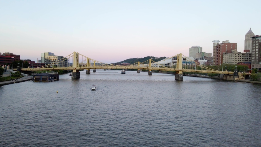 Aerial drone view low towards bridges on the Allegheny river, colorful evening in Pittsburgh, USA