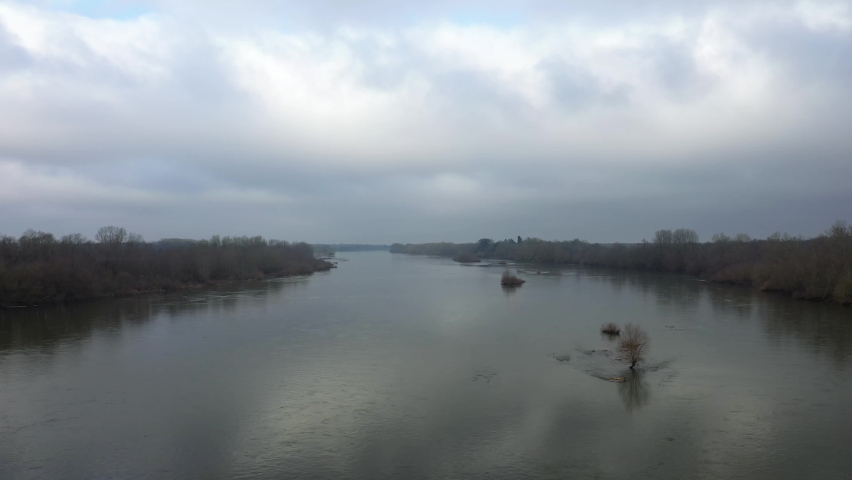 The Loire in the middle of the French countryside in Europe, in France, in the Center region, in the Loiret, towards Orléans, in Winter, during a cloudy day.