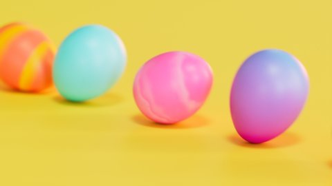 Seamless looping animation of multicolour Easter eggs on a yellow background. Happy Easter. A row of eggs rolling in one direction. Concept of traditional spring celebration. Symbol of new life.