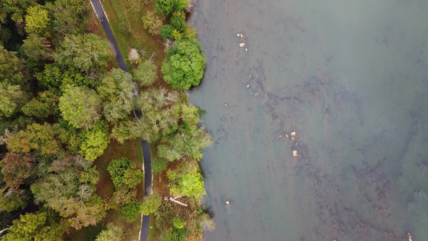 Aerial view of fitness trail with fall foliage and shallow river. Autumn on the Catawba River in South Carolina, USA.