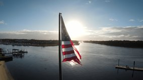 The American flag flies at dusk in a coastal town. - Powered by Shutterstock - Get 15% off with code: PIKWIZARD15