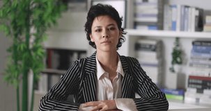 Short hairstyle businesswoman in casual suit sitting in home office during online conference and speaking explain to audience attendees. Concept of new normal business work and job assignment.