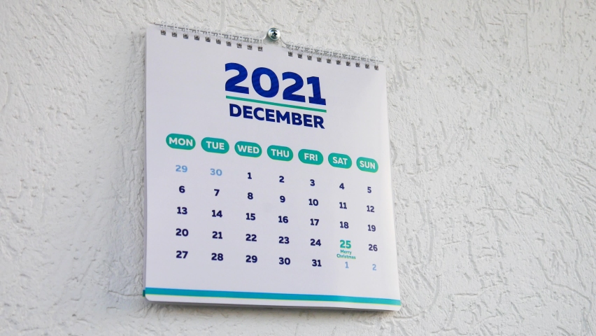 Close-up of male hands tearing off the December page of 2021 wall calendar followed by the January page of a new 2022 calendar Royalty-Free Stock Footage #1081272566
